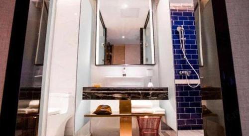 a bathroom with a sink and a mirror at Kyriad Marvelous Hotel Xiangyin Bus Station in Xiangyin
