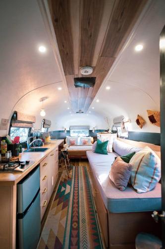 a living room with a couch in a rv at Silver Bullet Airstream, El Mistico Glamping Ranch in Nogal