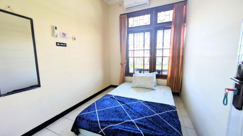 a room with a bed in a room with a window at Surabaya Homey Dharmahusada Syariah in Surabaya