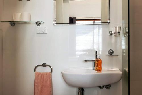 a bathroom with a white sink and a mirror at Coastal Breeze 2Bedrm 2Bath Pool & Slide in Perth