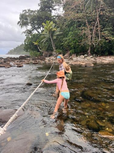 a woman and a girl in the water with a rope at Classic Fijian Home 