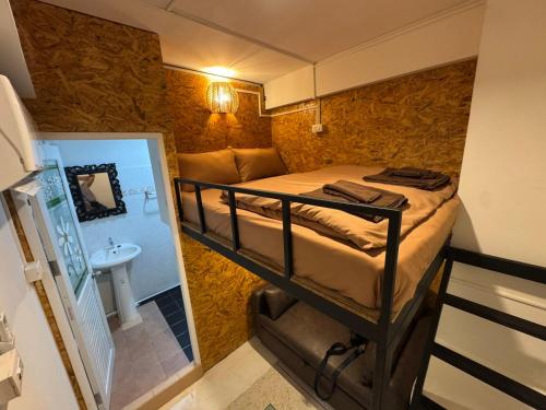 a small room with a bunk bed and a sink at Comfy Corner Hostel in Bangkok
