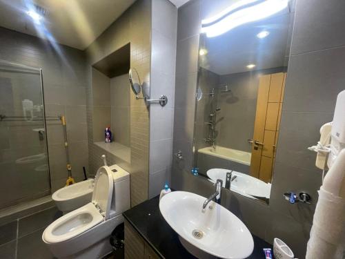 a bathroom with a sink and a toilet and a mirror at Bahrain Amwaj in Amwaj Island