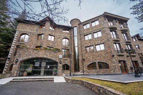 a large brick building with a lot of windows at Abba Xalet Suites Hotel in Sispony