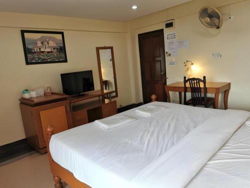 a bedroom with a large white bed and a desk at Hihotel Saraburi in Sara Buri