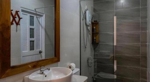 a bathroom with a sink and a shower with a mirror at HON BA LAGI BEACH RESORT in La Gi