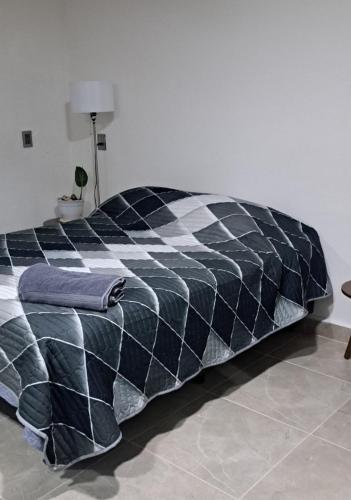 - une couette noire et blanche sur un lit dans la chambre dans l'établissement Habitación Ejecutiva Xico, Cedral SLP, à Cedral