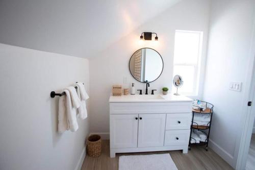 a white bathroom with a sink and a mirror at Stylish, Elegant, Modern, King Bed in San Diego