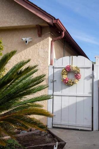 a white gate with a wreath on it next to a house at Stylish, Elegant, Modern, King Bed in San Diego