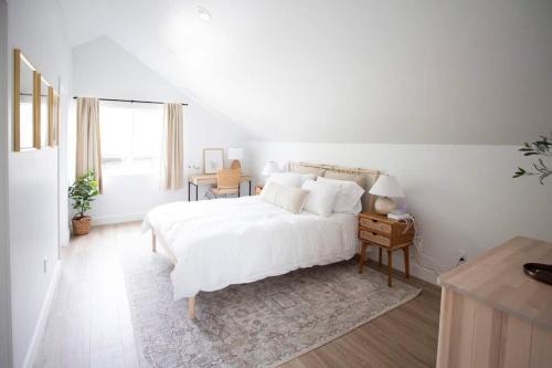 a white bedroom with a white bed and a table at Stylish, Elegant, Modern, King Bed in San Diego