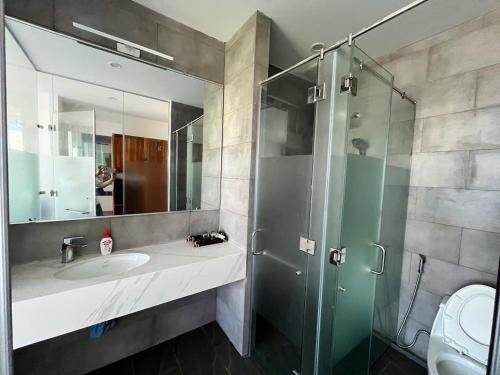 a bathroom with a sink and a glass shower at Beach villas ideal for families & groups to get together & retreat in Ấp Phước Tĩnh