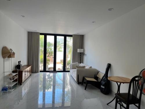 a living room with a couch and a table at Beach villas ideal for families & groups to get together & retreat in Ấp Phước Tĩnh