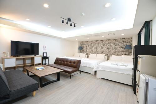 a hotel room with two beds and a flat screen tv at Shinjuku family apartment in Tokyo