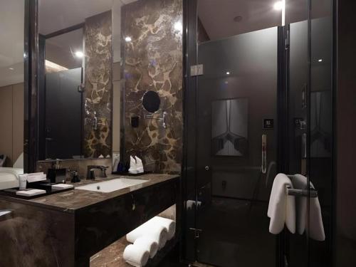 a bathroom with a sink and a shower at Zhonghao Boutique Hotel Dalang Business Center in Tiantangwei
