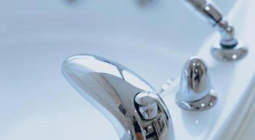 a close up of a bathroom sink with a faucet at Manhatton Hotel Beihai in Beihai