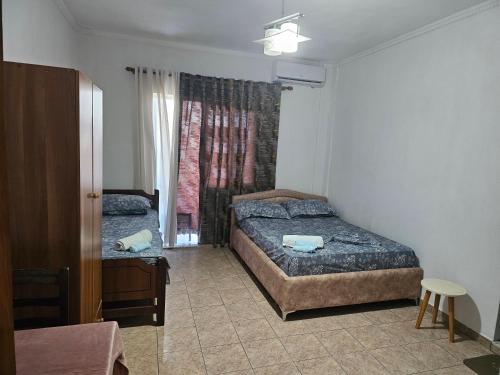 a bedroom with two beds and a window at Ajsi Apartments in Durrës