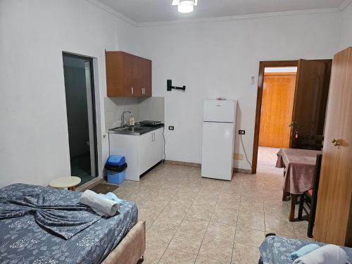 ドゥラスにあるAjsi Apartmentsのキッチン(冷蔵庫付)、ベッド1台が備わる客室です。