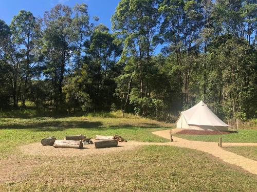 a white tent in a field next to a field at Amara Estate in Eumundi
