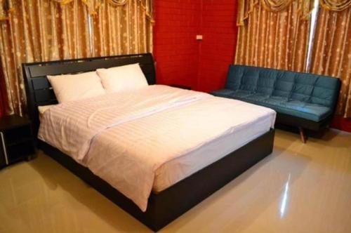 a bedroom with a bed and a blue couch at Lomdao Resort in Udon Thani