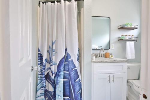 a bathroom with a shower curtain and a sink at Coastal Villa W Amazing Courtyard - Splash Pad! in Sarasota