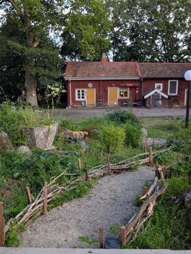 a house with a fence in front of a yard at Drängstugan in Kolbäck