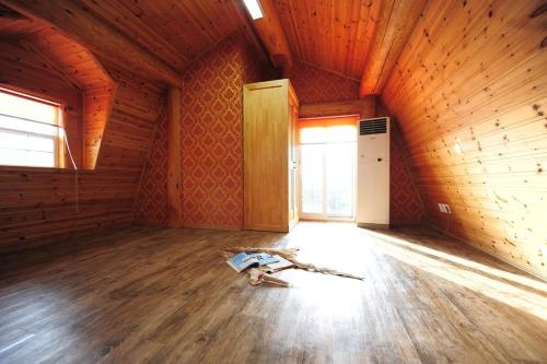 an empty room with a wooden ceiling and a wooden floor at Boryeong Rich Valley Log Village Pension in Boryeong