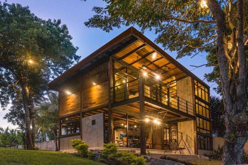 a house with large windows and lights on it at Casa Villa Real- Lagoon Acces And Stunning Views! in Bacalar