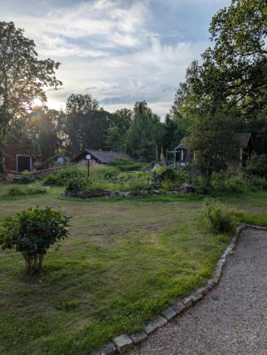 a yard with a house and a grass field at Drängstugan in Kolbäck