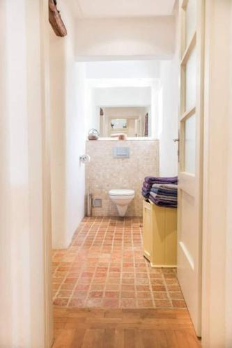 a bathroom with a toilet and a tile floor at Tolmin Center Apartments Townhouse & Loft in Tolmin