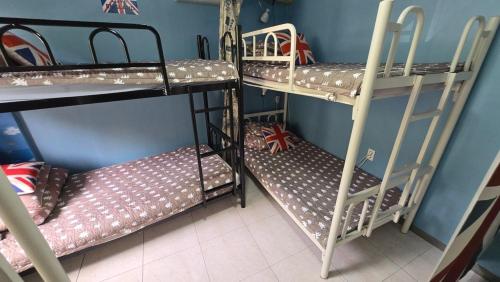 a room with three bunk beds and a room at Daegu Glens Guesthouse in Daegu