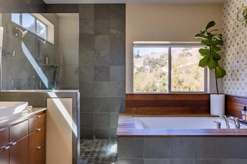 a bathroom with a large tub and a window at Mid Century Modern Family Home On 25 Acres! in Arroyo Grande