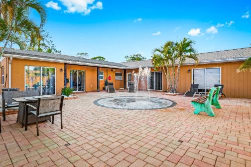 a patio with a fountain and a table and chairs at Coastal Villa W Amazing Courtyard - Splash Pad! in Sarasota