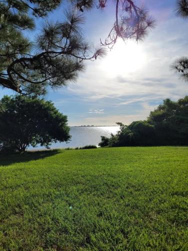 a field of green grass with the ocean in the background at Coastal Villa W Amazing Courtyard - Splash Pad! in Sarasota