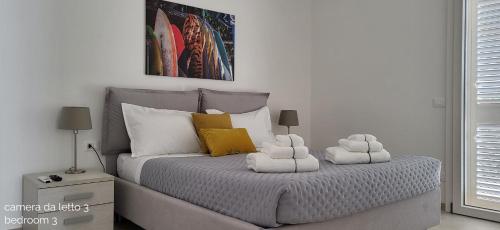 a bedroom with a bed with two towels on it at Villa Ballerina Bianca in Scopello