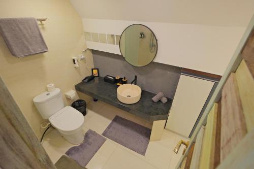 a small bathroom with a toilet and a mirror at Beautiful Penthouse w/ incredible views, pool, & cinema room! in Canggu