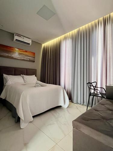 a bedroom with a white bed and a window at Casa, 01 Suíte, Ar-Cond, Área Gourmet e Garagem Ampla in Montes Claros