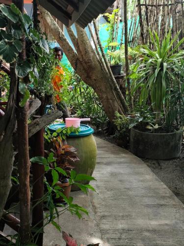a garden path with plants and a person in the background at Goodluck village house in Koh Mook