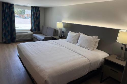a hotel room with a large bed and a chair at Baymont by Wyndham Rock Springs in Rock Springs