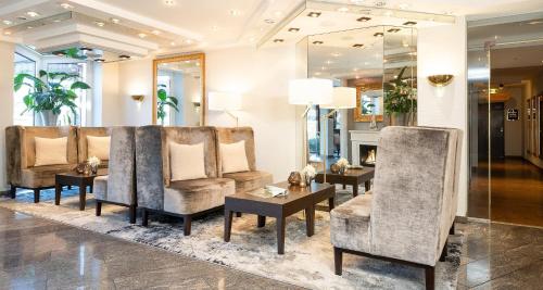 a lobby with chairs and a table and a fireplace at Best Western Victor's Residenz-Hotel Rodenhof in Saarbrücken