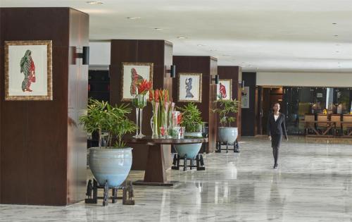 a woman walking through a lobby of a hotel at Hyatt Regency Dar es Salaam, The Kilimanjaro in Dar es Salaam