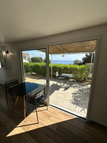 a room with a table and chairs and a patio at Home Cassis - Maison Méditerranée - Piscine chauffée à 30c in Cassis