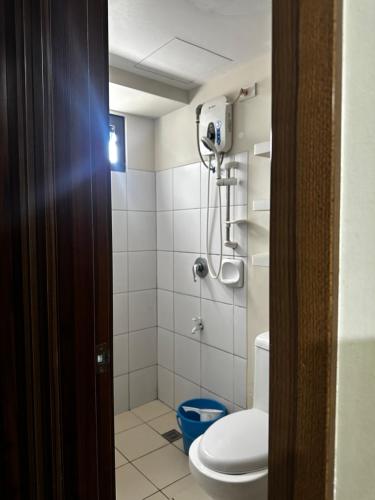 a bathroom with a toilet and a shower at Jojies Crib Horizons101 2bedrooms in Cebu City