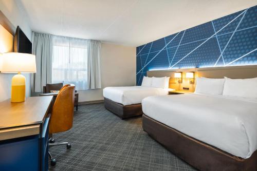 a hotel room with two beds and a desk at Comfort Inn & Suites in Barrie