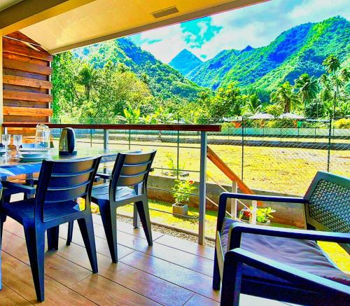 a restaurant with a table and chairs and a view of the mountains at Teahupo'o Lodge Tahiti - Studio Tropical - climatisé - entre randonnées et activités nautiques in Teahupoo