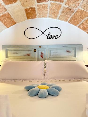 a bed with two pillows and a sign that says love at B&B Casa Fiore in Polignano a Mare