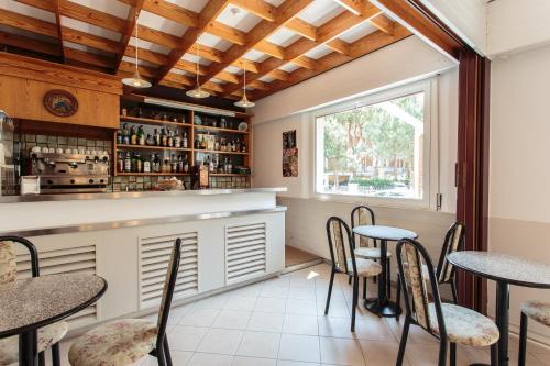 ミラノ・マリッティマにあるHotel Villa Ombrosaのレストランのテーブルと椅子付きのバー