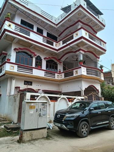 a black car parked in front of a house at Shri SeetaRam Home Stay Near Shri Ram Janmabhoomi Mandir Ayodhya in Ayodhya