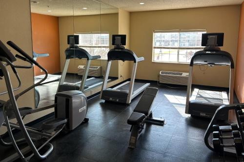 a gym with several tread machines in a room at Country Inn & Suites by Radisson, Owatonna, MN in Owatonna