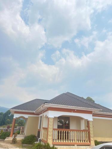 a house with a porch and a roof at Kibugu Gorilla Homestay in Kisoro