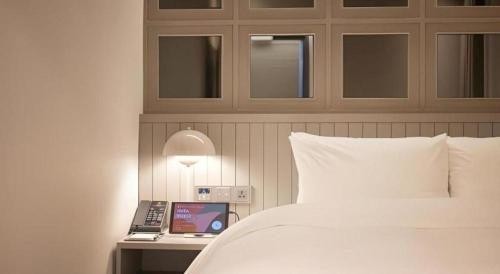 a bedroom with a bed and a desk with a laptop at HOTEL D EDITION in Daejeon